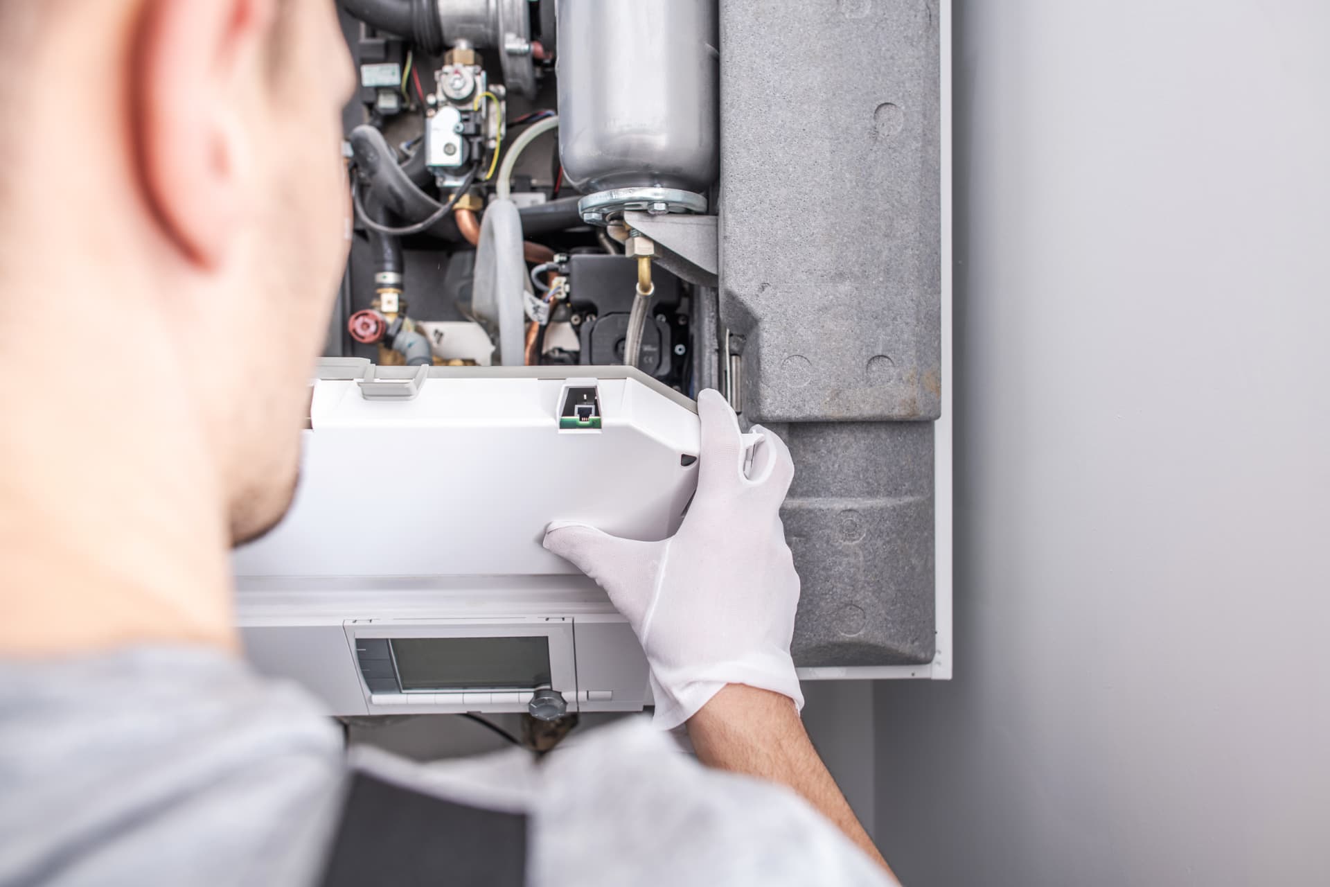 Technician servicing a wall-mounted boiler