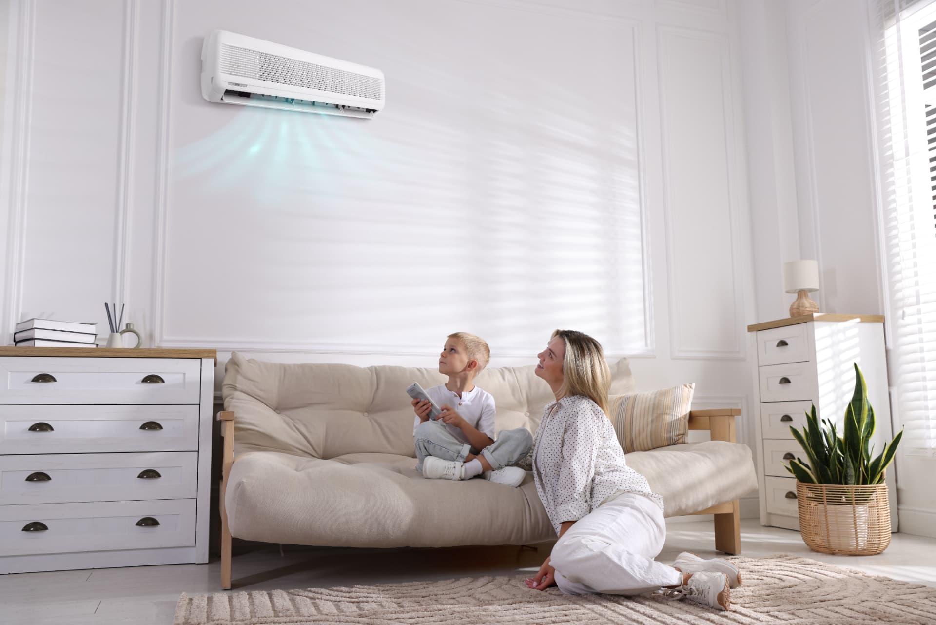 Mother and son relaxing in a cool living room with a wall-mounted air conditioner